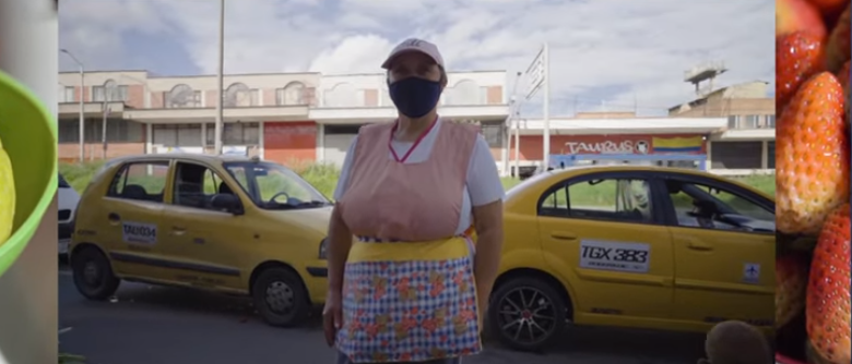 Woman with apron, mask and cap in the background of taxis