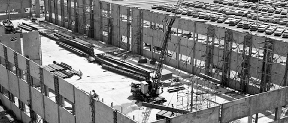 Black and white image of a building under construction. 